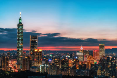 Illuminated buildings in city against sky at night