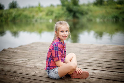 Portrait of boy sitting on pier