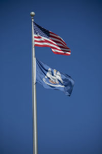 Low angle view of flag against blue sky