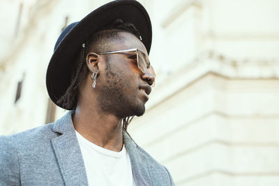 Fashionable young man looking away in city