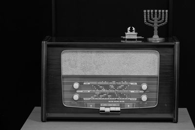 Close-up of telephone booth on table against black background