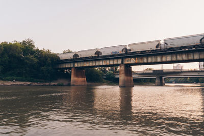 Low angle view of bridge over river against clear sky