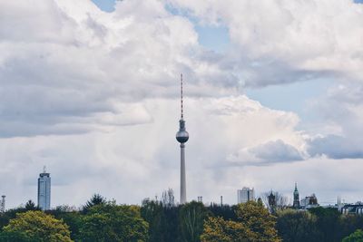 Low angle view of fernsehturm against cloudy sky