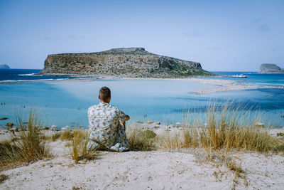 Rear view of woman looking at sea against sky