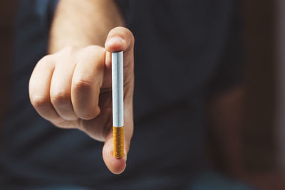 Close-up of hand holding cigarette