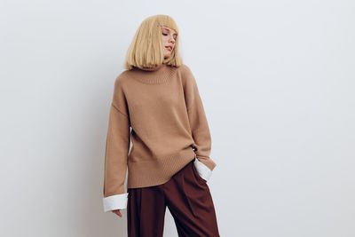 Portrait of woman standing against white background