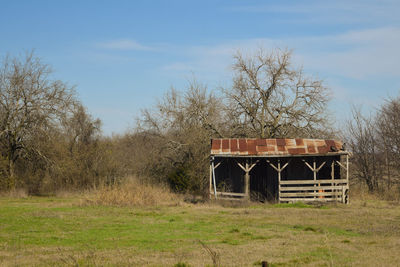 Abandoned house on field against sky