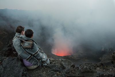 Rear view of people on rock against sky