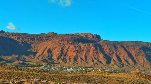 Panoramic view of mountain range against blue sky