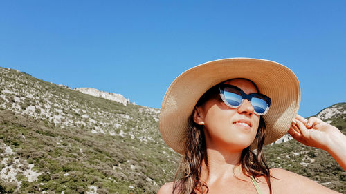 Portrait of young woman in summer. reflection of sea in sunglasses.