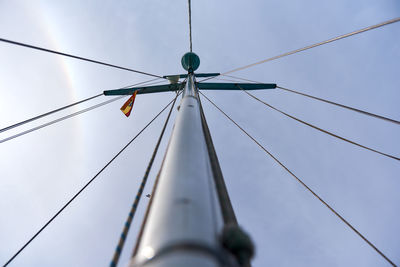 Low angle view of mast against cloudy sky