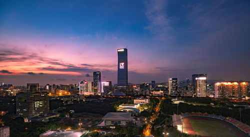 Illuminated modern buildings against sky at night