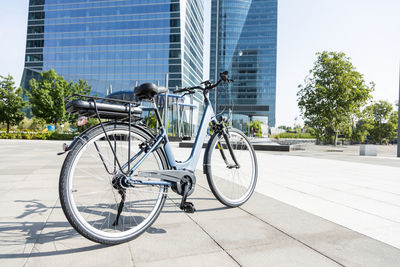 Contemporary blue bike parked on paved street in city center on sunny day