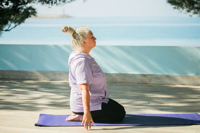 Full length of woman doing yoga on beach