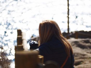 Rear view of woman photographing against sky