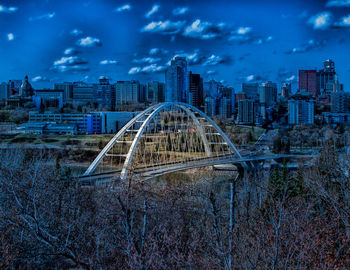 Arch bridge over river against buildings in city