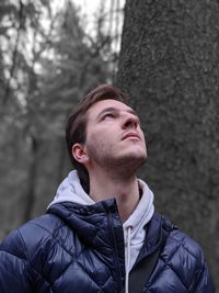 Portrait of young man looking away outdoors