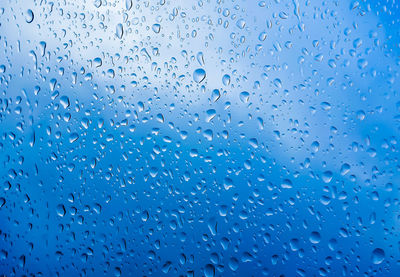 Full frame shot of wet glass window during rainy season