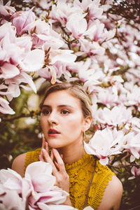 Young woman amidst pink flowers during springtime