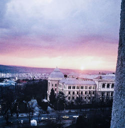 Buildings against cloudy sky at sunset