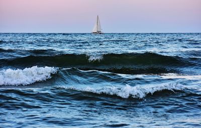 Sailboat in sea against clear sky