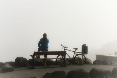 Rear view of a young woman sitting on bench