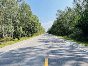 Road amidst trees against sky