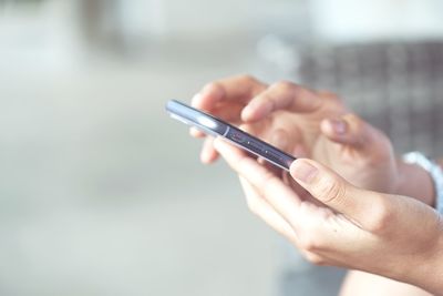 Women's hands use a smartphone for online shopping, social networking, or remote work.