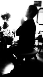 Rear view of a silhouette woman sitting at restaurant