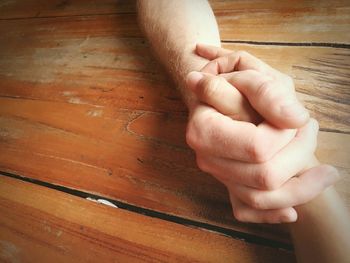 Close-up of man hand on wood