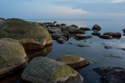 Rocks by sea against sky