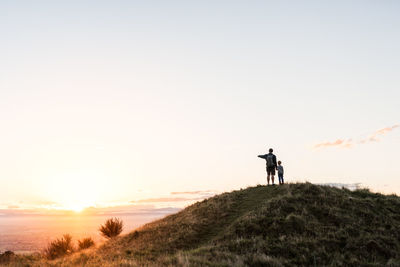 Dad and child watching beautiful sunset in new zealand
