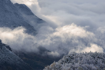 Low angle view of snowcapped mountains against sky