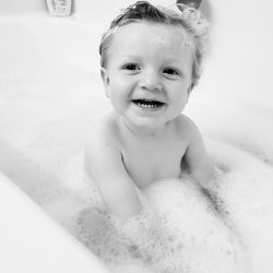 Portrait of cute boy smiling in bathtub