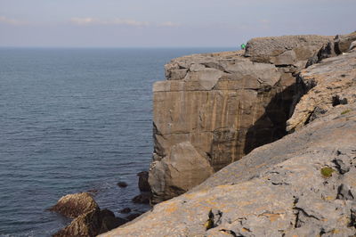 Rock formations by sea against sky
