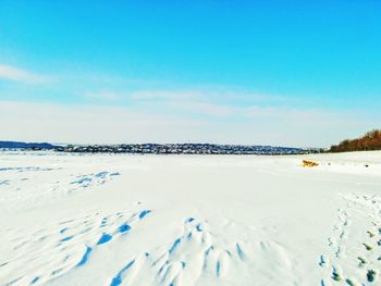 Scenic view of frozen landscape against blue sky