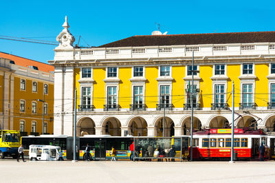 People by tram at praca do comercio on street in city