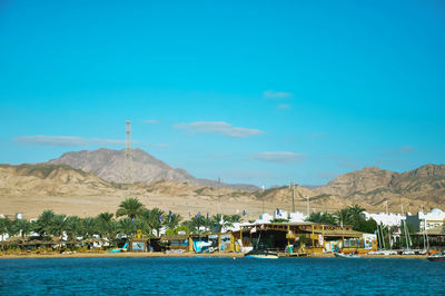 Scenic view of lake and mountains against blue sky