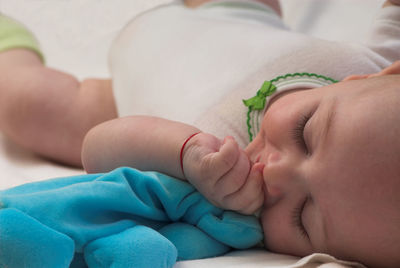 Close-up of baby sleeping on bed