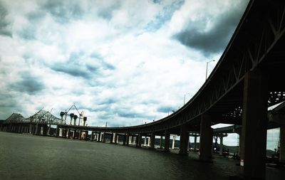 Bridge against cloudy sky