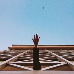 Low angle view of hand against clear sky