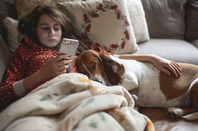 Midsection of man with dog lying on bed