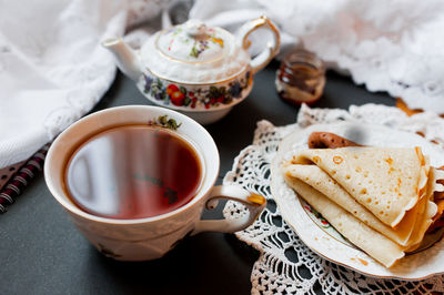 Beautiful version of breakfast with white porcelain cup and pancakes. maslenitsa