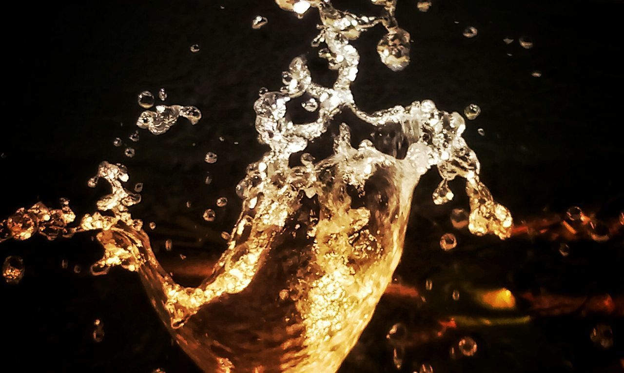CLOSE-UP OF ILLUMINATED BUBBLES WITH REFLECTION IN WATER