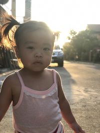 Portrait of cute baby girl standing on road