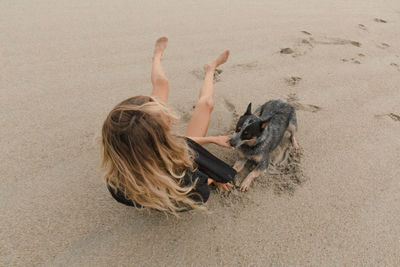 Woman lying down on sand at beach