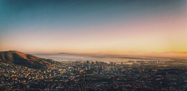 Aerial view of cityscape and sea at sunset