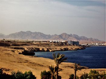 Scenic view of sea and mountains against sky