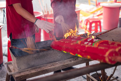 Midsection of man working on barbecue grill