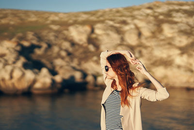 Woman with umbrella standing at shore